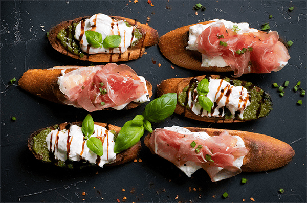 Crèmige Burrata auf Crostini mit Pesto oder Rohschinken
